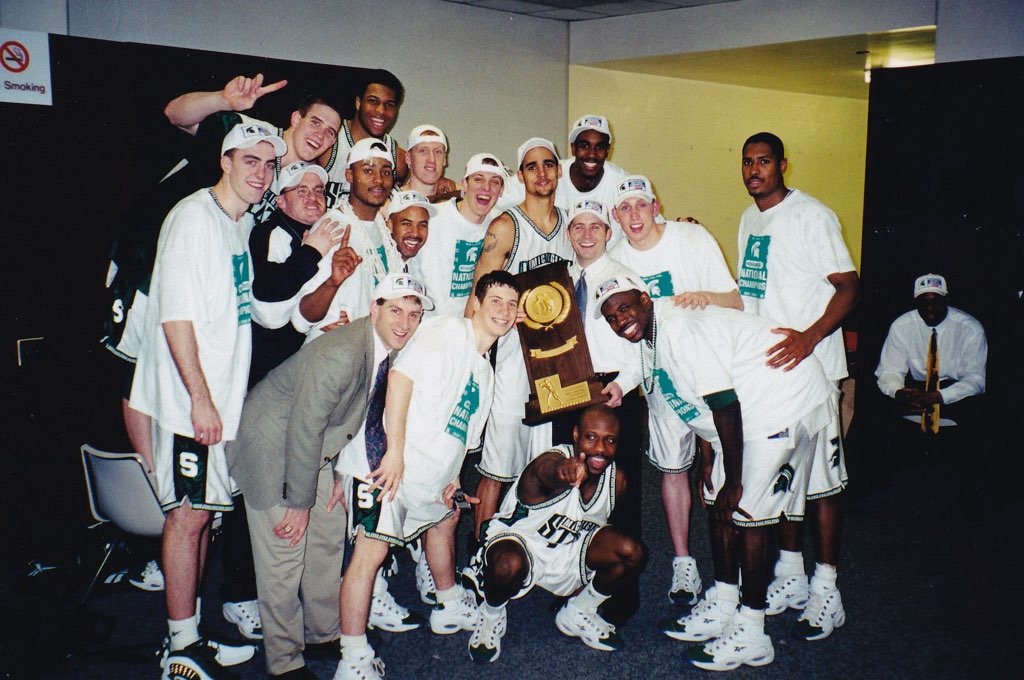 2000 Michigan State Basketball team celebrating with the National Championship trophy in the locker room