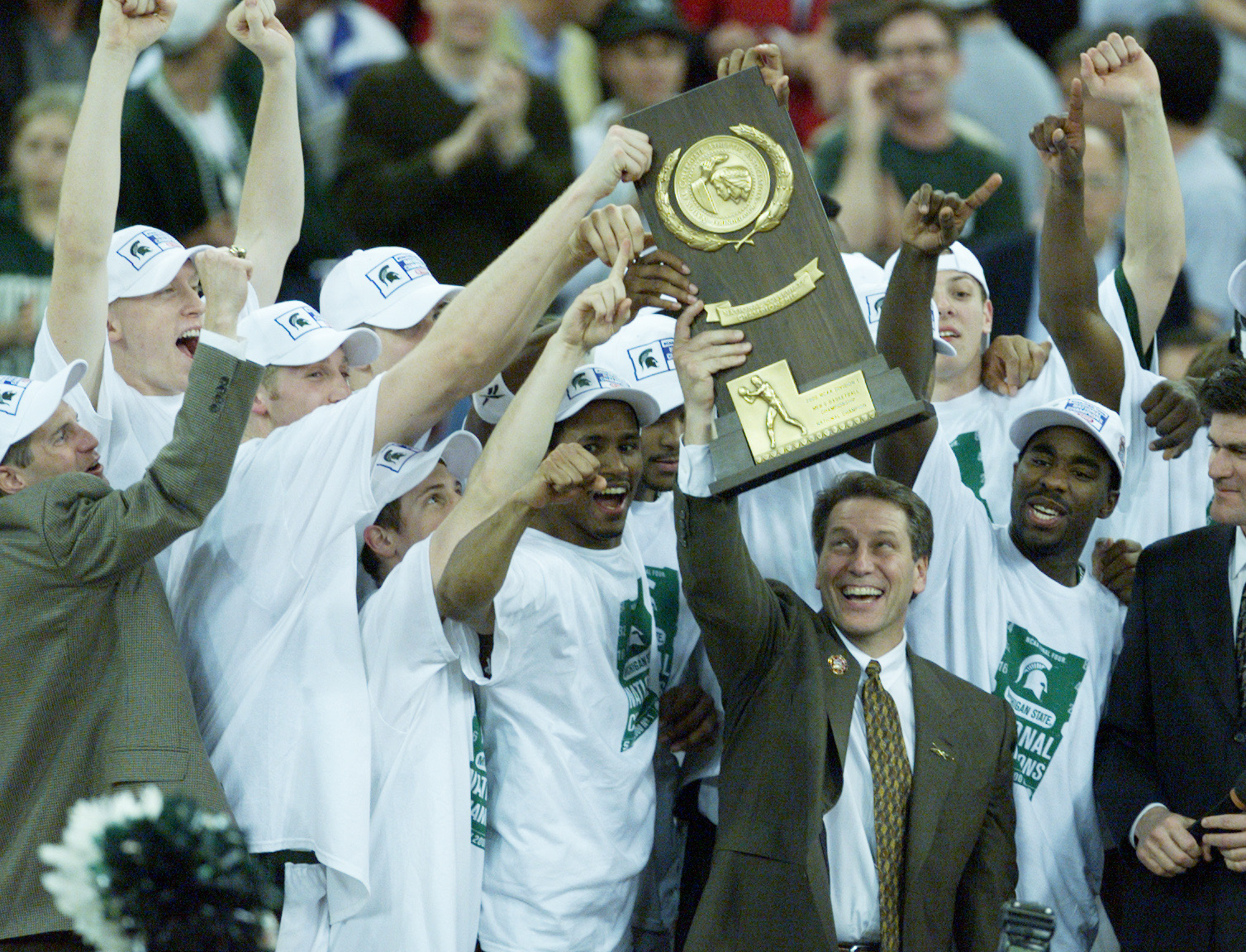Coach Tom Izzo and the 2000 Michigan State Spartans hoisting the NCAA National Championship trophy