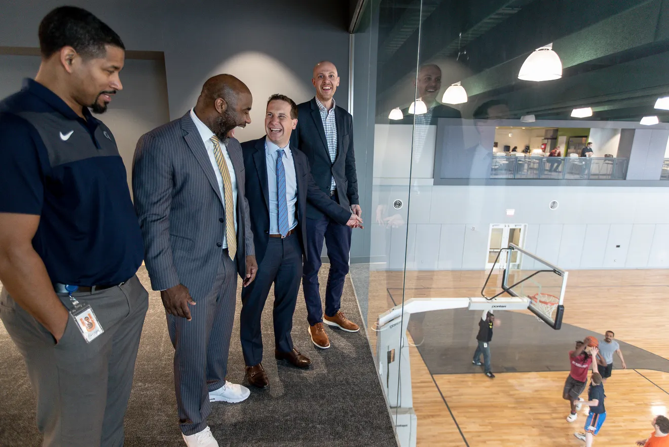 Charlie Bell, Mateen Cleaves, Mat Ishbia, and Adam Wolfe overlooking the basketball court at UWM